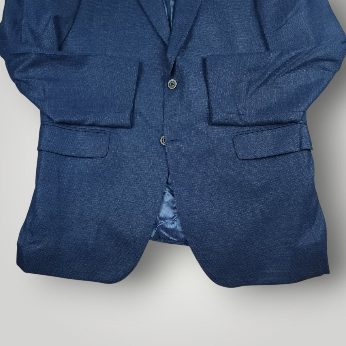 Front lower detail of blue hopsack wool sport coat showing button stance and pocket placement.