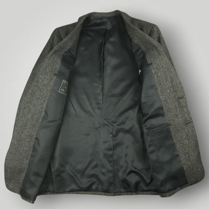 Interior view of a gray herringbone tweed jacket with black lining