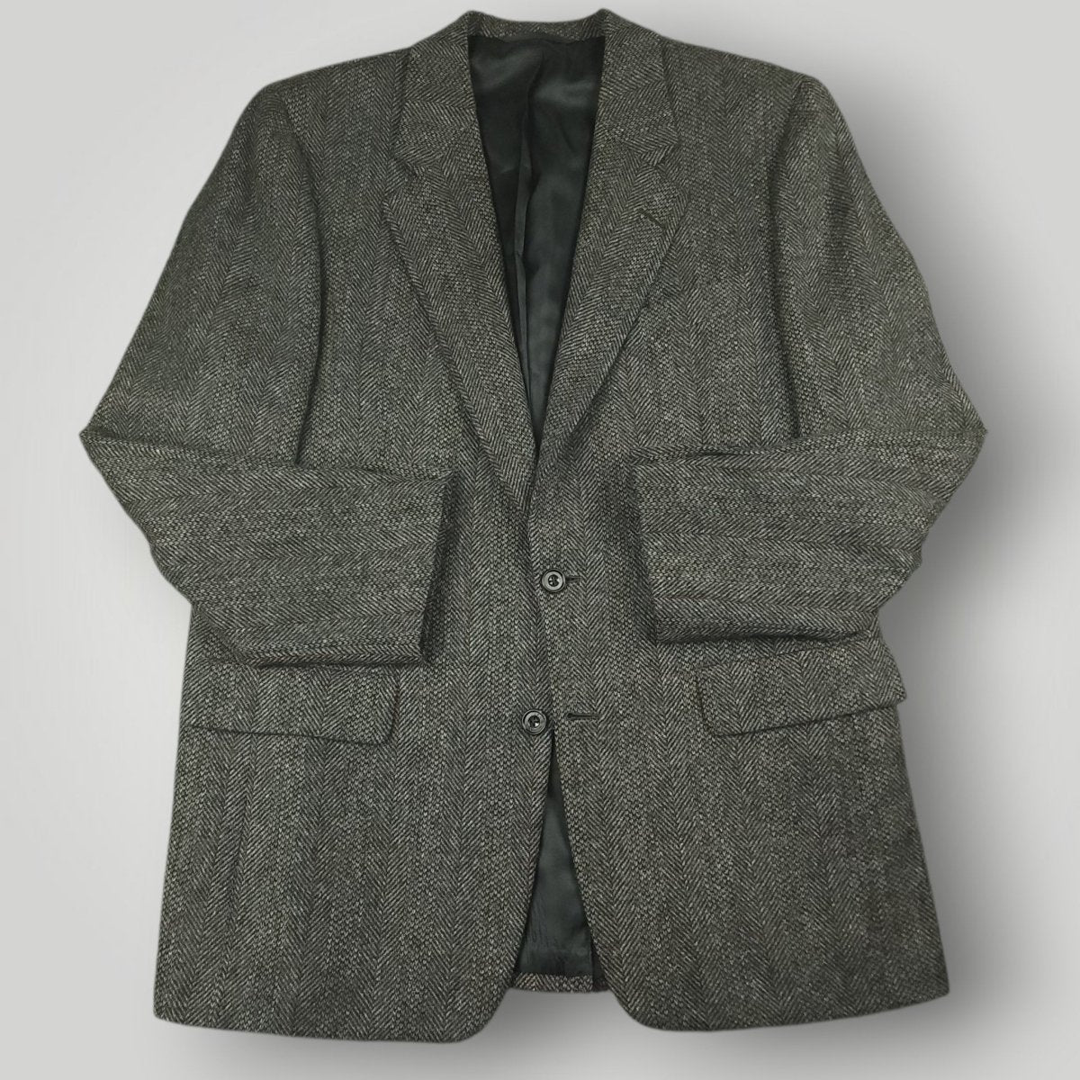 Gray herringbone tweed jacket with notched lapels and flap pockets