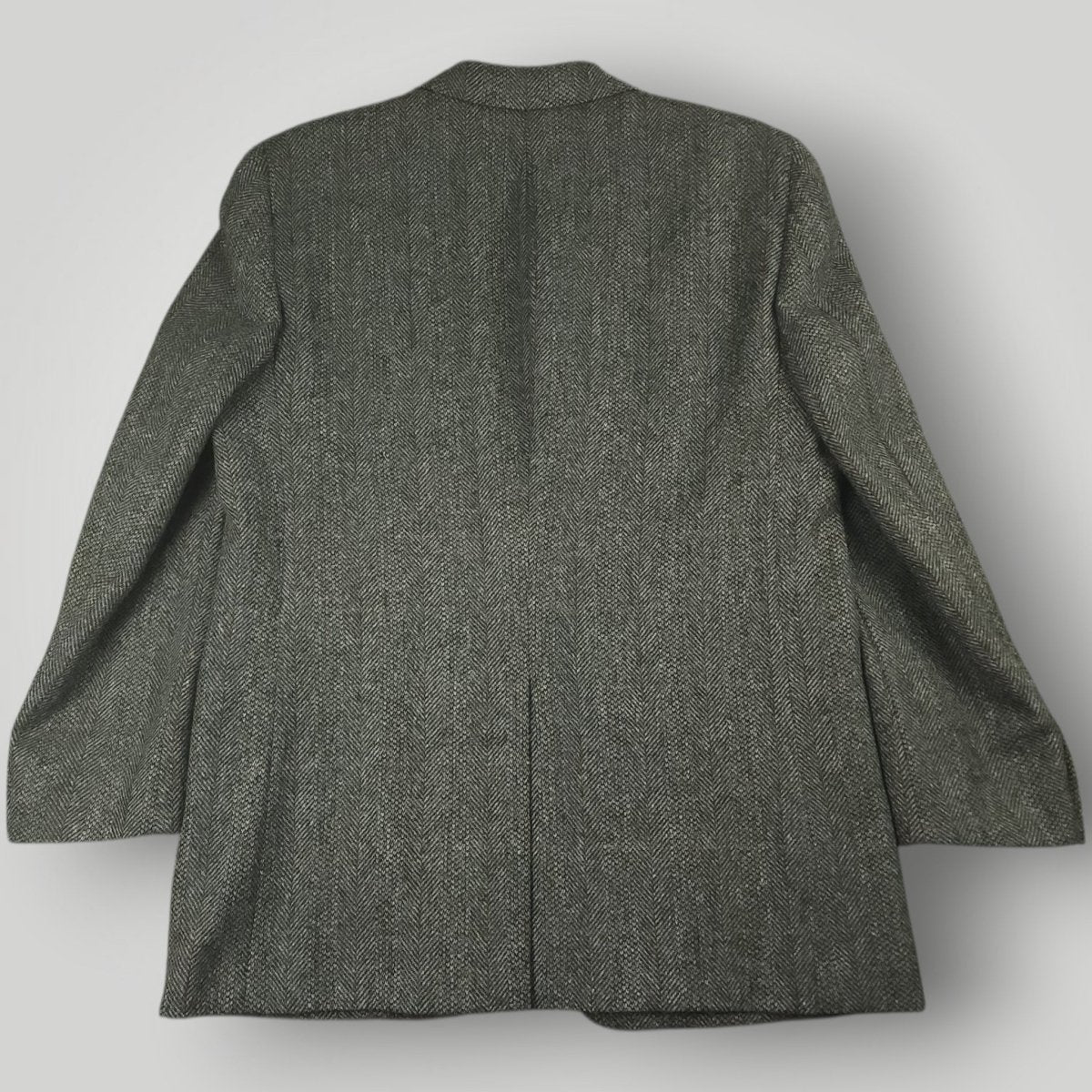 Back view of a gray herringbone tweed jacket with a center vent