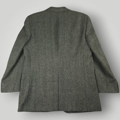 Back view of a gray herringbone tweed jacket with a center vent