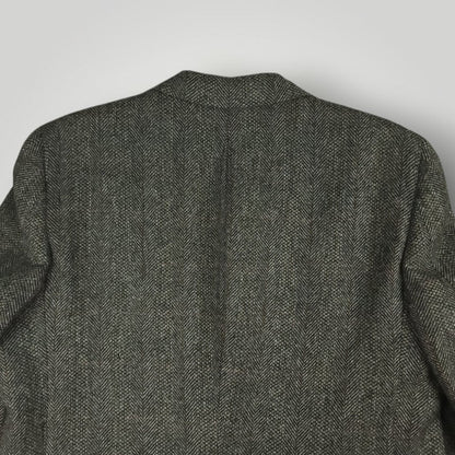 Back view of a gray herringbone tweed jacket showing the shoulder and collar area