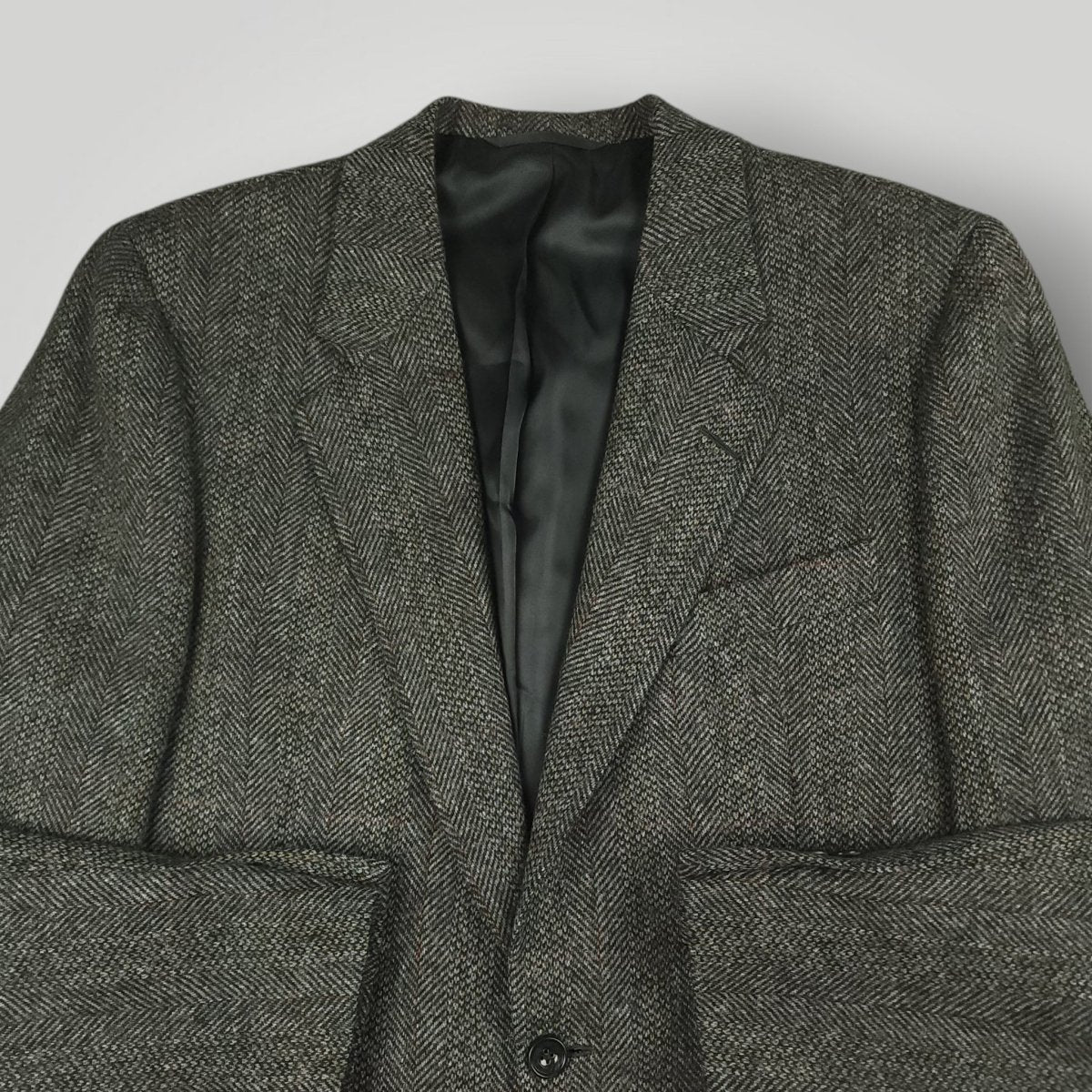 Gray herringbone tweed jacket with notch lapels and flap pockets