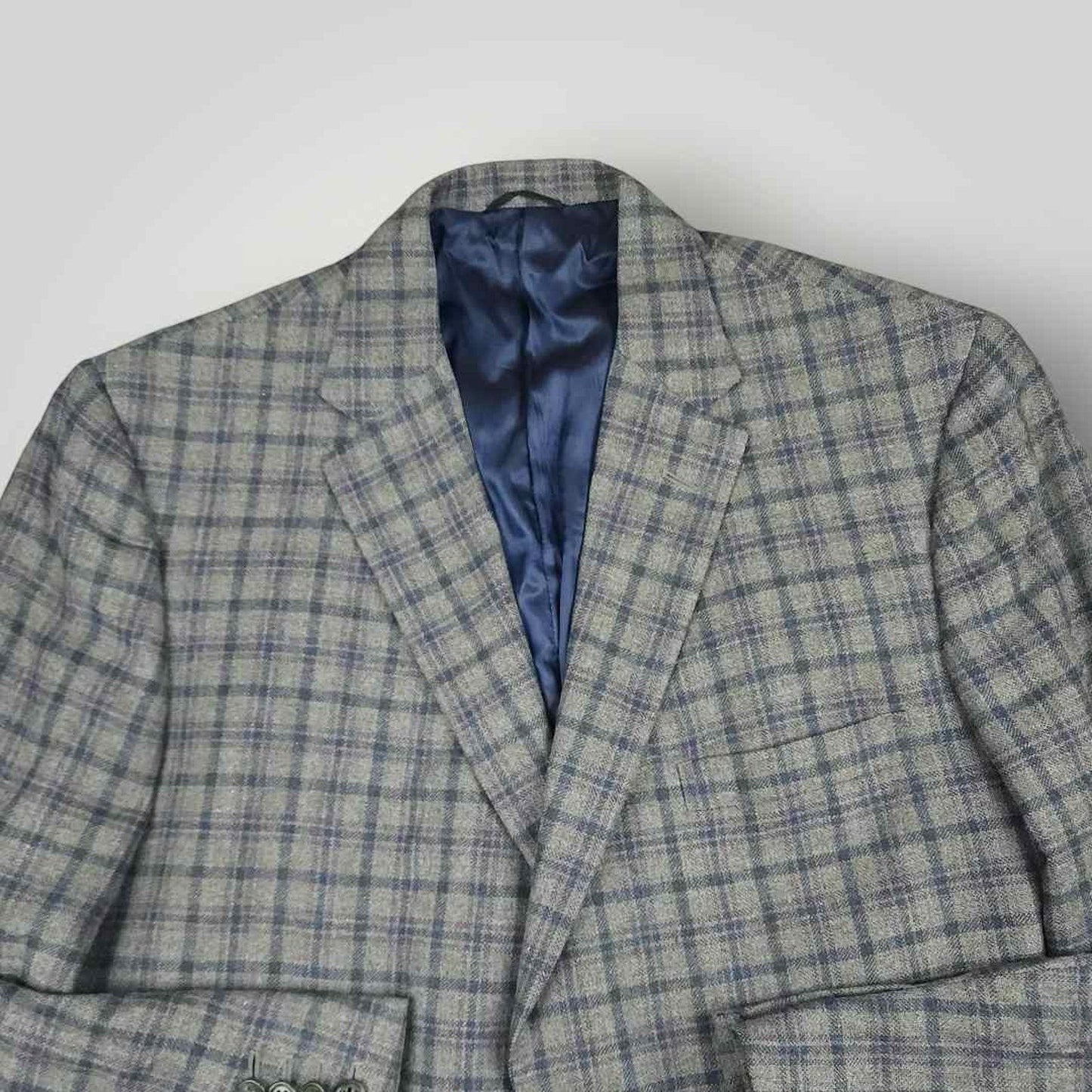 Open front view of Tom James Innocenti plaid wool sport coat displaying blue lining and interior craftsmanship.