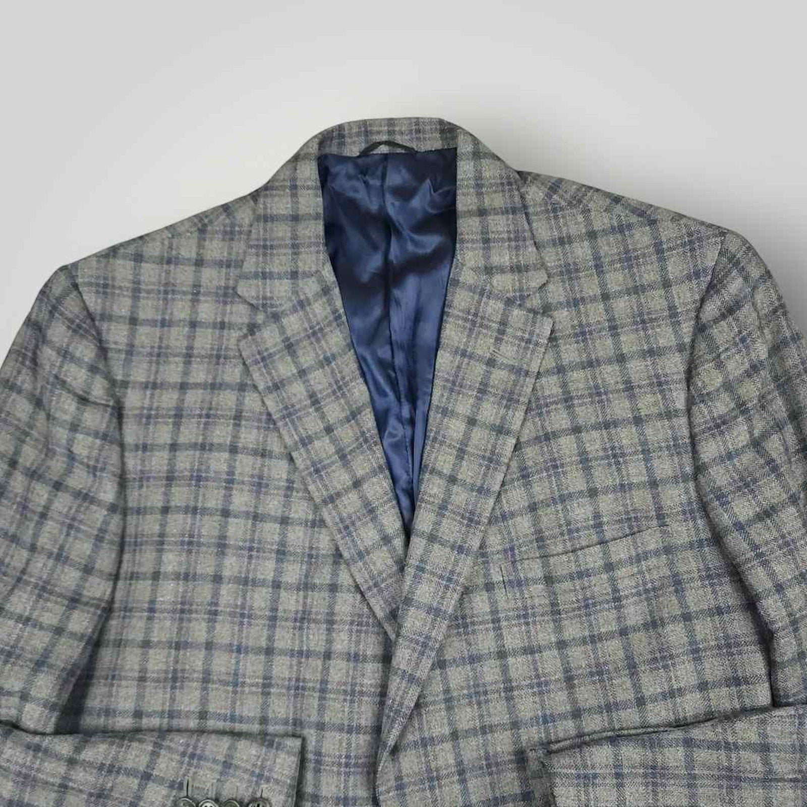 Open front view of Tom James Innocenti plaid wool sport coat displaying blue lining and interior craftsmanship.