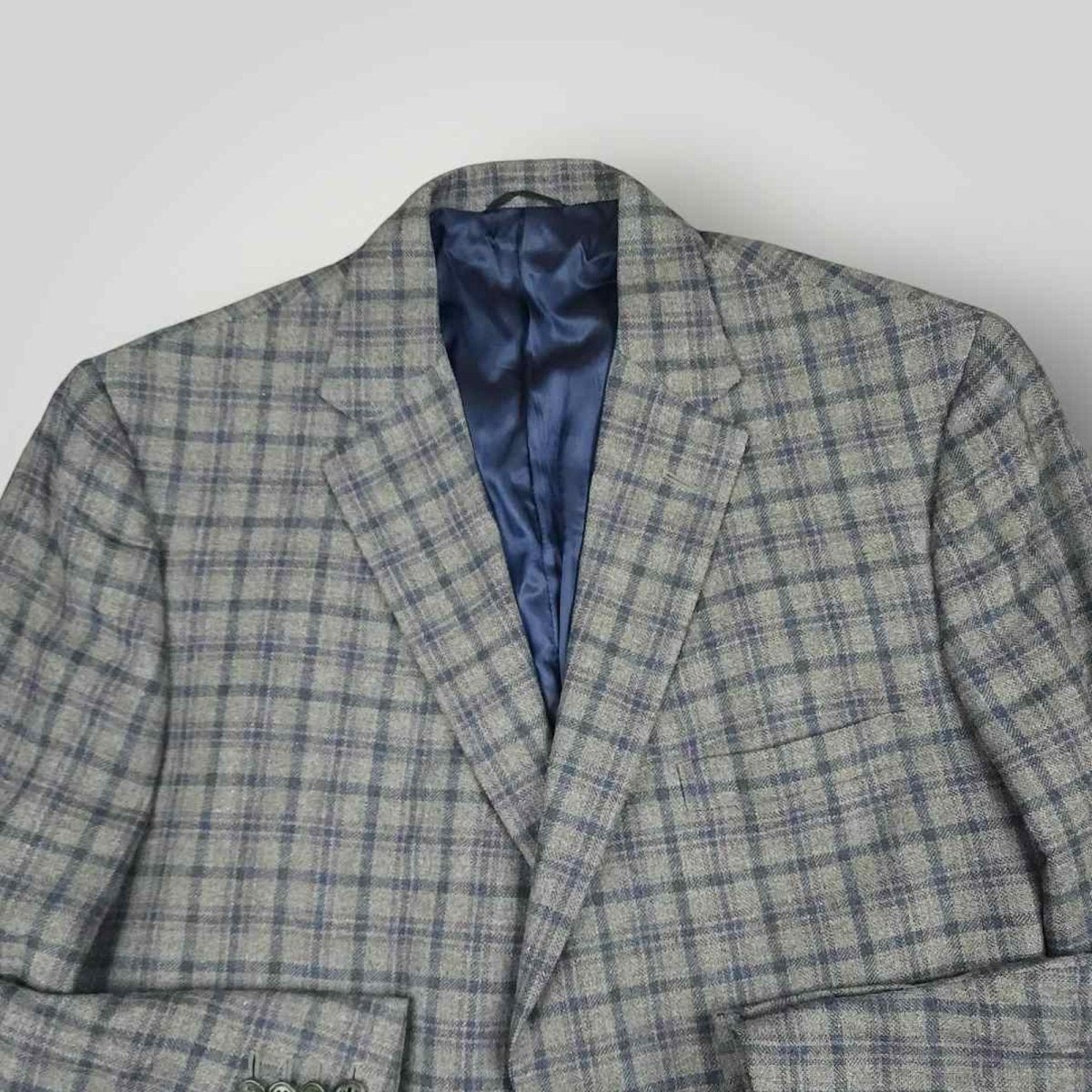 Open front view of Tom James Innocenti plaid wool sport coat displaying blue lining and interior craftsmanship.