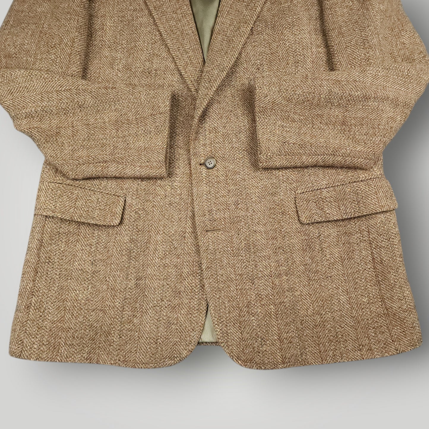 Close up of flap pockets and herringbone wool fabric on Harris Tweed blazer